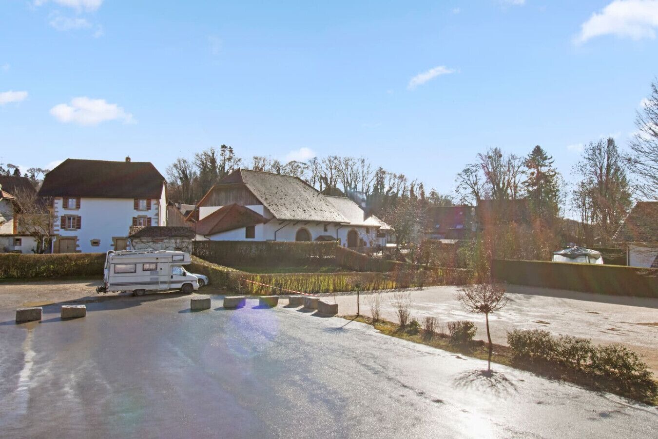 Un quartier résidentiel avec des maisons, un camping-car garé et une allée pavée.
