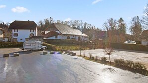 Un quartier résidentiel avec des maisons, un camping-car garé et une allée pavée.