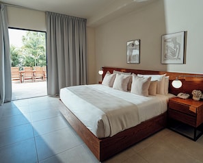 A hotel room with a large bed, a wooden headboard, a bedside table with a lamp, and artwork on the wall. - Lifestyle Holiday Vacation Club (Puerto Plata)