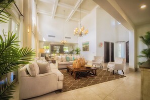 A spacious living room with a high ceiling, a chandelier, and a large coffee table. - Lifestyle Holiday Vacation Club (Puerto Plata)
