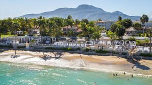 A beachfront hotel with palm trees, a sandy beach, and a mountain in the background. - Lifestyle Holiday Vacation Club (Puerto Plata)