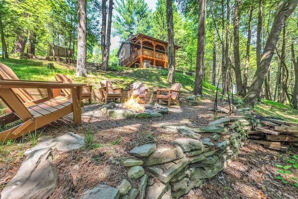 Eine Holzhütte mit Steinwand und Holzboden, umgeben von Bäumen.