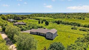 A residential area with houses, green lawns, and a view of the ocean. - Chace Point by the Ocean (Little Compton)