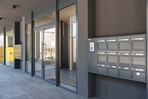 A modern building entrance with glass doors, a mail slot, and a tiled floor. - Design Apartment Gottardo With Views Over Lugano (Massagno)