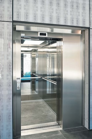 A modern elevator with metallic walls and a glass door. - Design Apartment Gottardo With Views Over Lugano (Massagno)