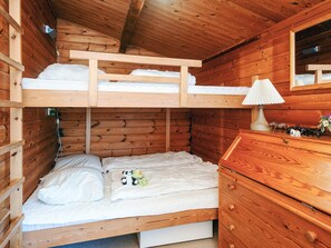 A bunk bed with a wooden headboard, a bedside lamp, a dresser, and a small panda toy on the lower bed. - 5 Person Holiday Home in Fano (Fano)