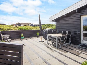 A patio with a table and chairs, a barbecue grill, and a potted plant. - 5 Person Holiday Home in Fano (Fano)