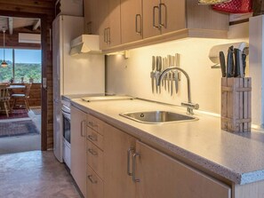A kitchen with a sink, wooden cabinets, and a knife block. - 5 Person Holiday Home in Fano (Fano)