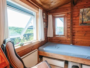 A compact wooden cabin room with a bed, a small table, and a chair. - 5 Person Holiday Home in Fano (Fano)