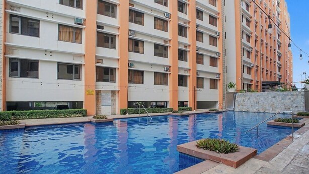 Un edificio residencial de varios pisos con una piscina.