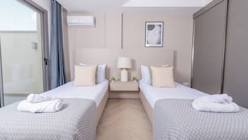 A hotel room with two beds, a nightstand with a lamp, and a picture on the wall.