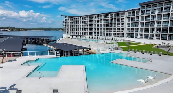 Un hôtel moderne doté d’une grande piscine, d’un quai et offrant une vue sur l’eau.