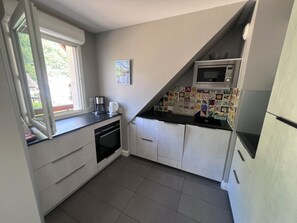 A compact kitchen with a microwave, coffee maker, and a small oven.