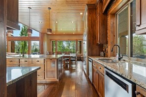 Eine geräumige Küche mit Holzschränken, Granit Arbeitsplatten und einer großen Kochinsel.