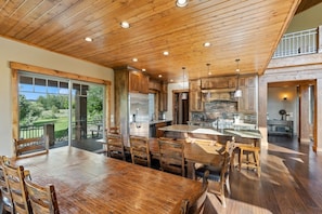A spacious kitchen with wooden cabinetry, a large island, and a view of the outdoors. - The Shores Estate - 2 Luxury Lodges (Ashton)