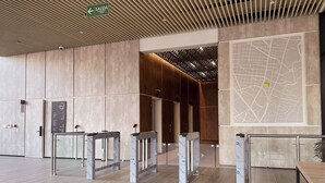 Een modern interieur met een houten plafond, een kaart aan de muur en een groen vluchtroutebord.