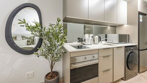 Moderni keittiö, jossa on sisäänrakennettu uuni, mikroaaltouuni ja astianpesukone.