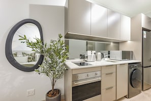 A modern kitchen with a built-in oven, microwave, and dishwasher. - One Rosebank: Urban Haven Studio (Johannesburg)