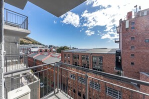 A high-rise building with a balcony overlooking a cityscape. - Charlie and the Chairman | CBD Retreat | Balcony (Cape Town)
