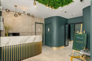 A reception area with a marble counter, a green wall, and a welcome sign. - Skyline Escape | Views, Pool and Braai (Cape Town)