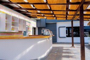 Ein modernes Interieur mit einer gewölbten Theke, einer mit Fliesen verkleideten Wand und einer Decke aus Holzlamellen.