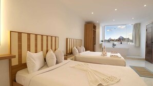 Habitación de hotel con dos camas, un ventanal con vistas, una bañera y un armario.