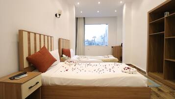 Een hotelkamer met een groot bed, een nachtkastje, een houten garderobe en een raam met uitzicht.