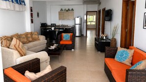 Una sala de estar con sofá, mesa de centro y comedor con sillas y una mesa.