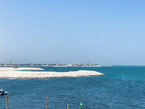 Eine Küstenansicht mit einem Yachthafen, Booten und einem Sandstrand.