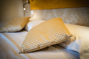 A bed with a patterned pillow and a plain pillow. - Hotel Walter Room with Wi-Fi and Air Conditioning (Venice)