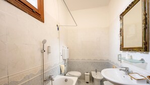 Et badeværelse med badekar, toilet, bidet og håndvask.