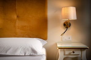 Ein Hotelzimmer mit einem Bett, einem Nachttisch mit Lampe und einer Steckdose.