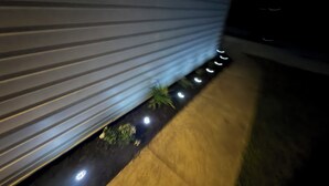 A modern building exterior with horizontal siding, a concrete pathway, and small, evenly spaced lights along the base. - Cozy 1-bedroom in a spacious house with AC in charming Powder Springs (Powder Springs)