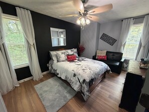 A bedroom with a bed, a ceiling fan, a dresser, and a window with curtains. - Cozy 1-bedroom in a spacious house with AC in charming Powder Springs (Powder Springs)