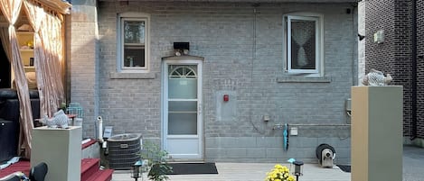 A two-story house with a front door, a small porch, and a brick chimney.