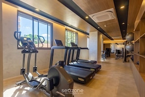 Ein Fitnessstudio mit Laufbändern, Crosstrainern und Trainingsgeräten.
