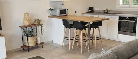 A modern kitchen with a dining area, a sofa, and a coffee table.