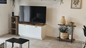 Ein Wohnzimmer mit Flachbildfernseher, einer Uhr und einem Regal mit Dekoration.