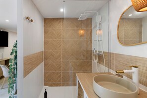 Une salle de bain moderne avec une douche, un lavabo et un miroir.