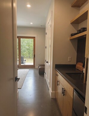 Una cocina moderna con armarios de madera, encimera negra y horno integrado.
