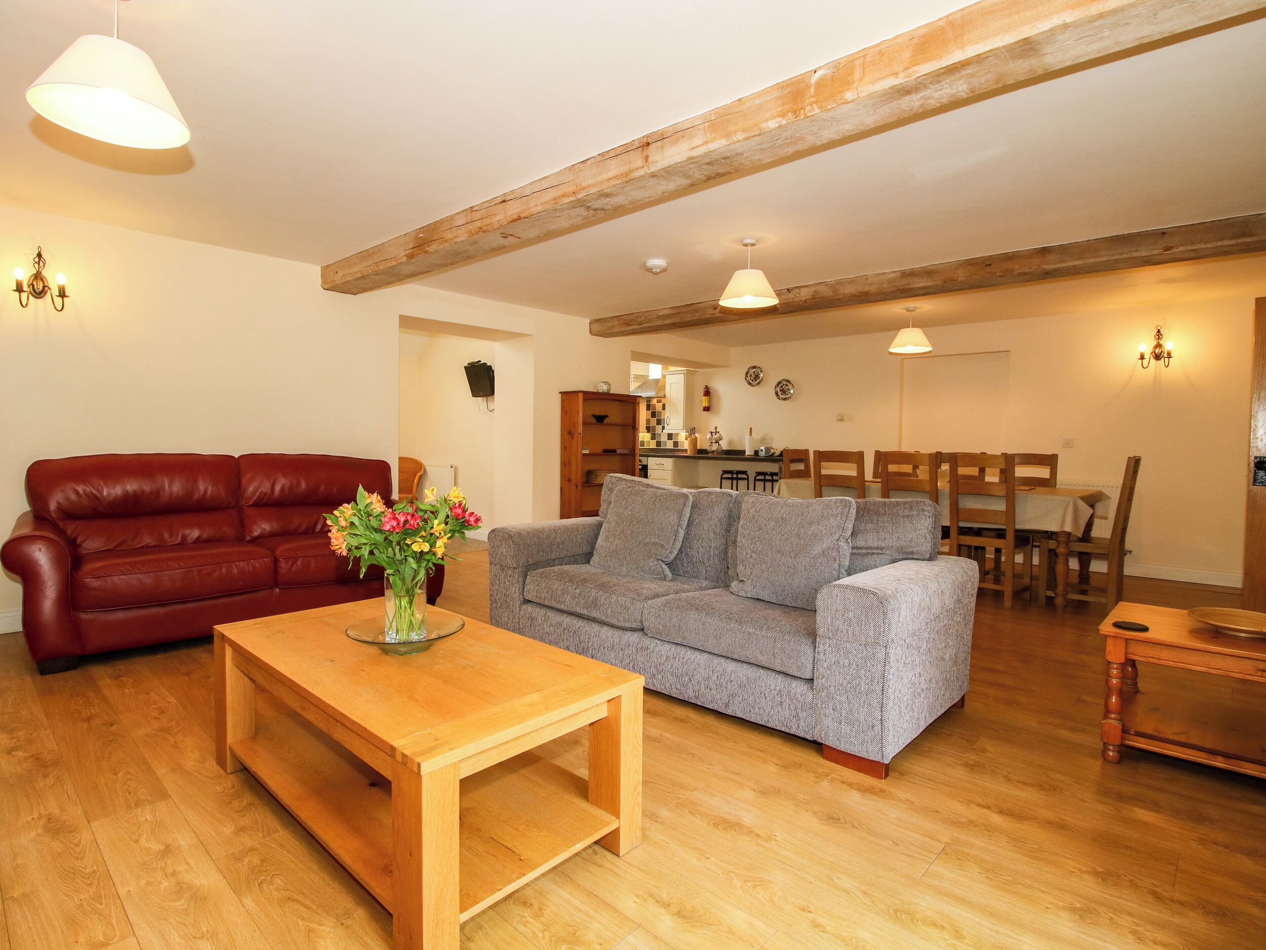 Una sala de estar con una mesa de centro de madera, dos sofás y un comedor con sillas y una mesa.
