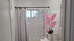 Une petite salle de bain comprenant une douche, des toilettes et un lavabo.