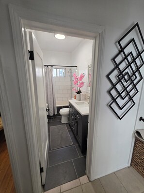 A bathroom with a shower, toilet, and sink. - Cozy 1-Bedroom Urban Retreat with Modern Comforts (Los Angeles)
