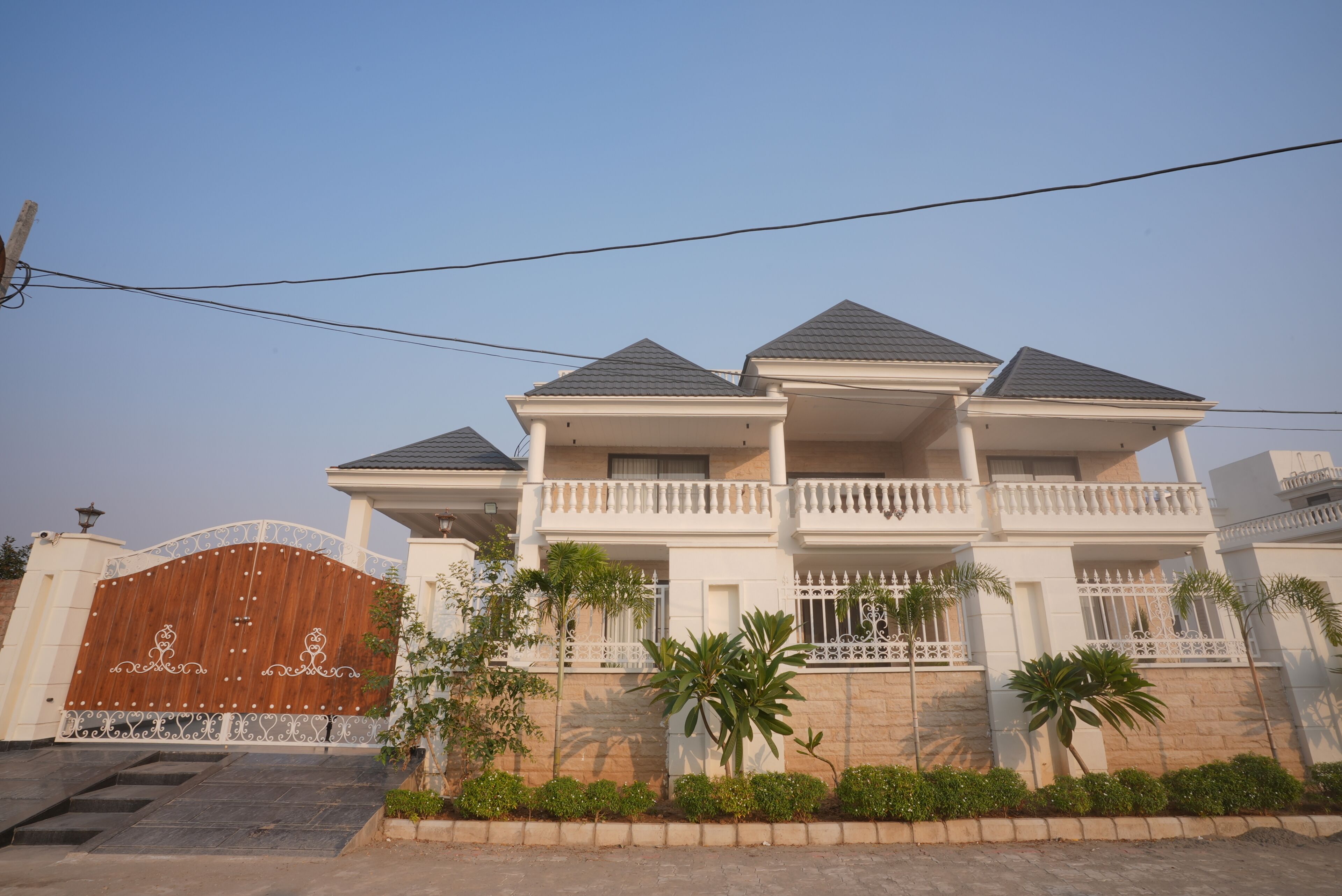 A multi-story residential building with a gated entrance, balconies, and a well-maintained garden.