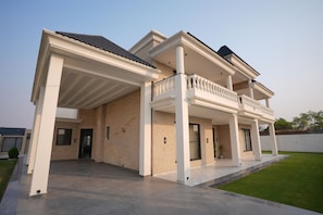 A modern two-story house with a covered patio, a balcony, and a well-maintained lawn. - Kaayanaat Luxury Villa Amritsar Airport (Amritsar)