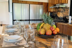 Une cuisine dotée d’un plan de travail en marbre, d’appareils électroménagers en acier inoxydable et d’un panier à fruits.