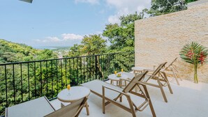 Ein Balkon mit Blick auf eine üppige Landschaft und eine ferne Stadt.
