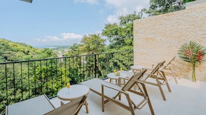A balcony with a view of a lush landscape and a distant town. - Luxury Brand New : Casa Rambutan - 3BR (Quepos)
