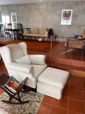 Una sala de estar con un sofá, un reposapiés y una mesita baja con libros.