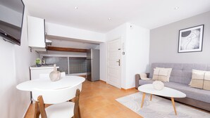Un espacio habitable compacto con cocina, comedor y sofá.